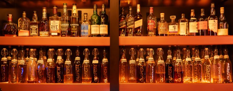 “Infused spirits bottles behind the bar at Element Bar in Casco Viejo, Panama”