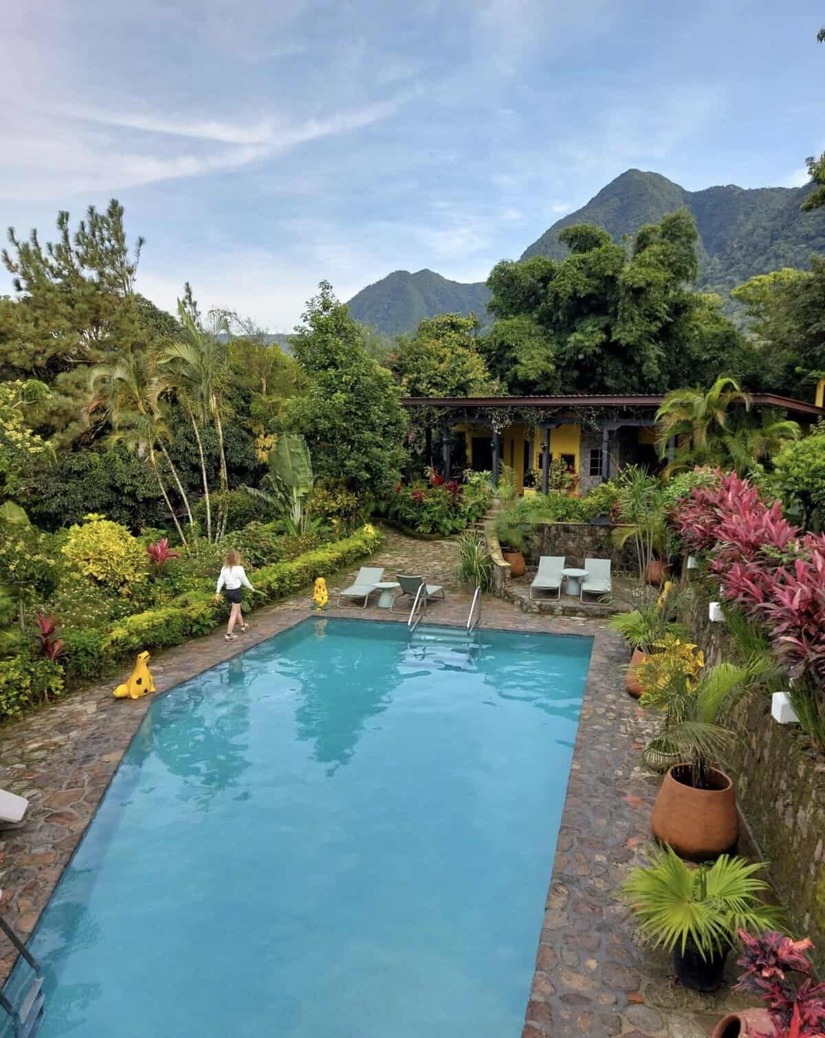 Swimming pool surrounded by tropical gardens and mountains at The Golden Frog Inn in El Valle de Antón.