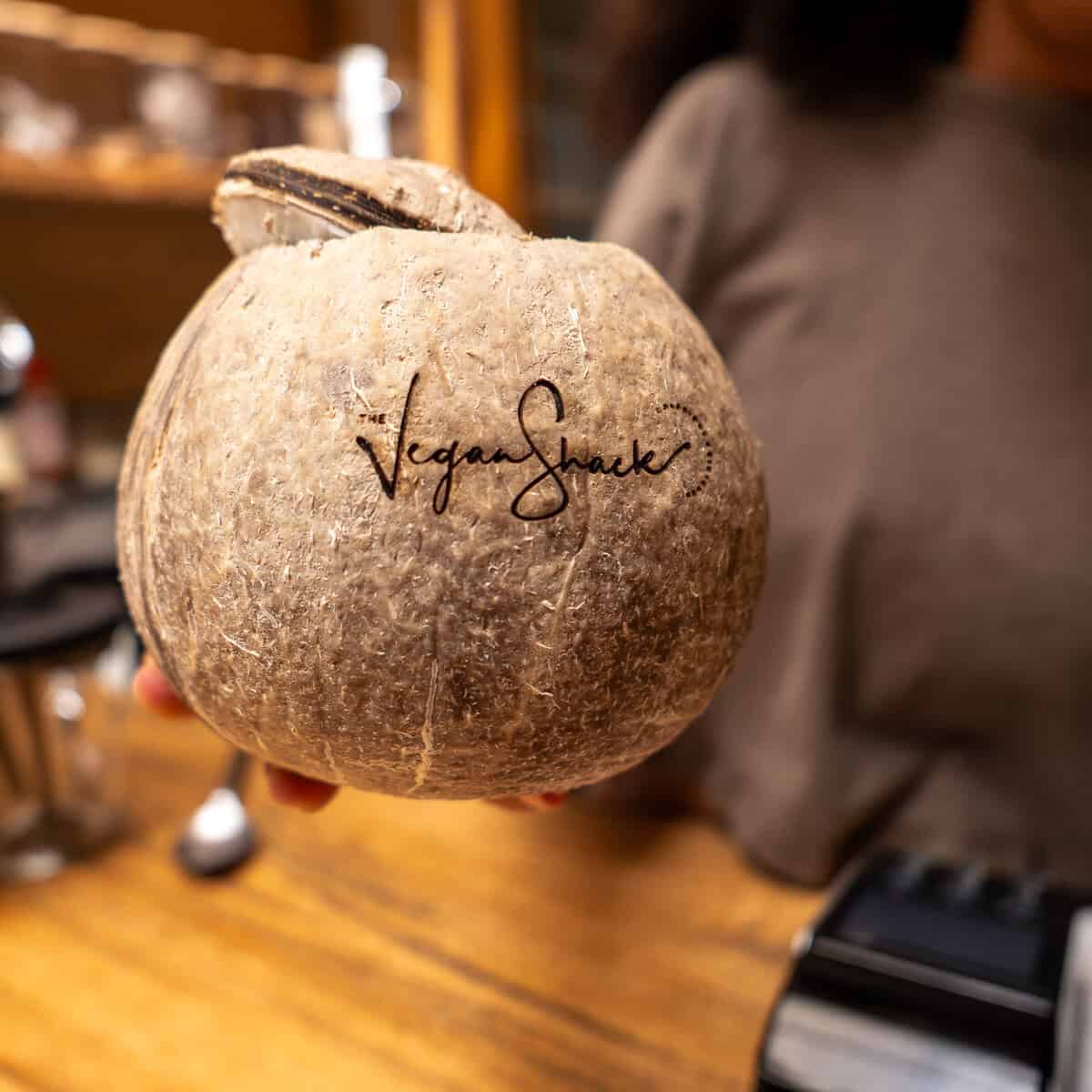 Fresh coconut water served in an opened coconut with a straw at The Vegan Shack in Casco Viejo.