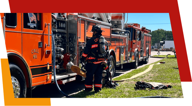Firefighter preparing hose near fire truck