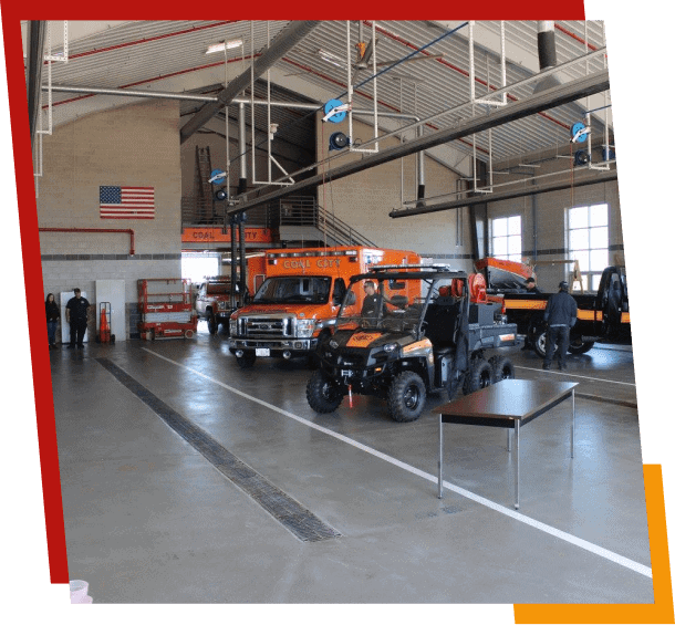 Firefighters maintaining vehicles in fire station garage