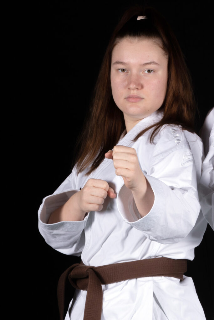 Karateka in Kampfstellung mit braunem Gürtel.