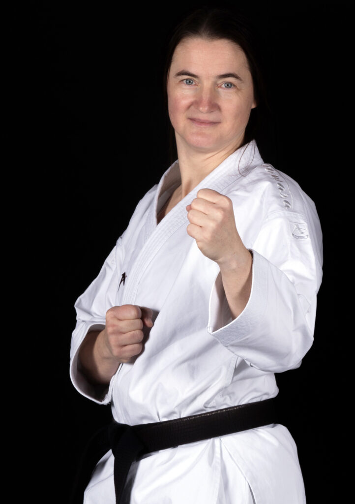 Karateka mit Schwarzgurt posiert im Gi.