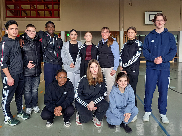 Sportmannschaft in Sporthalle gruppiert.