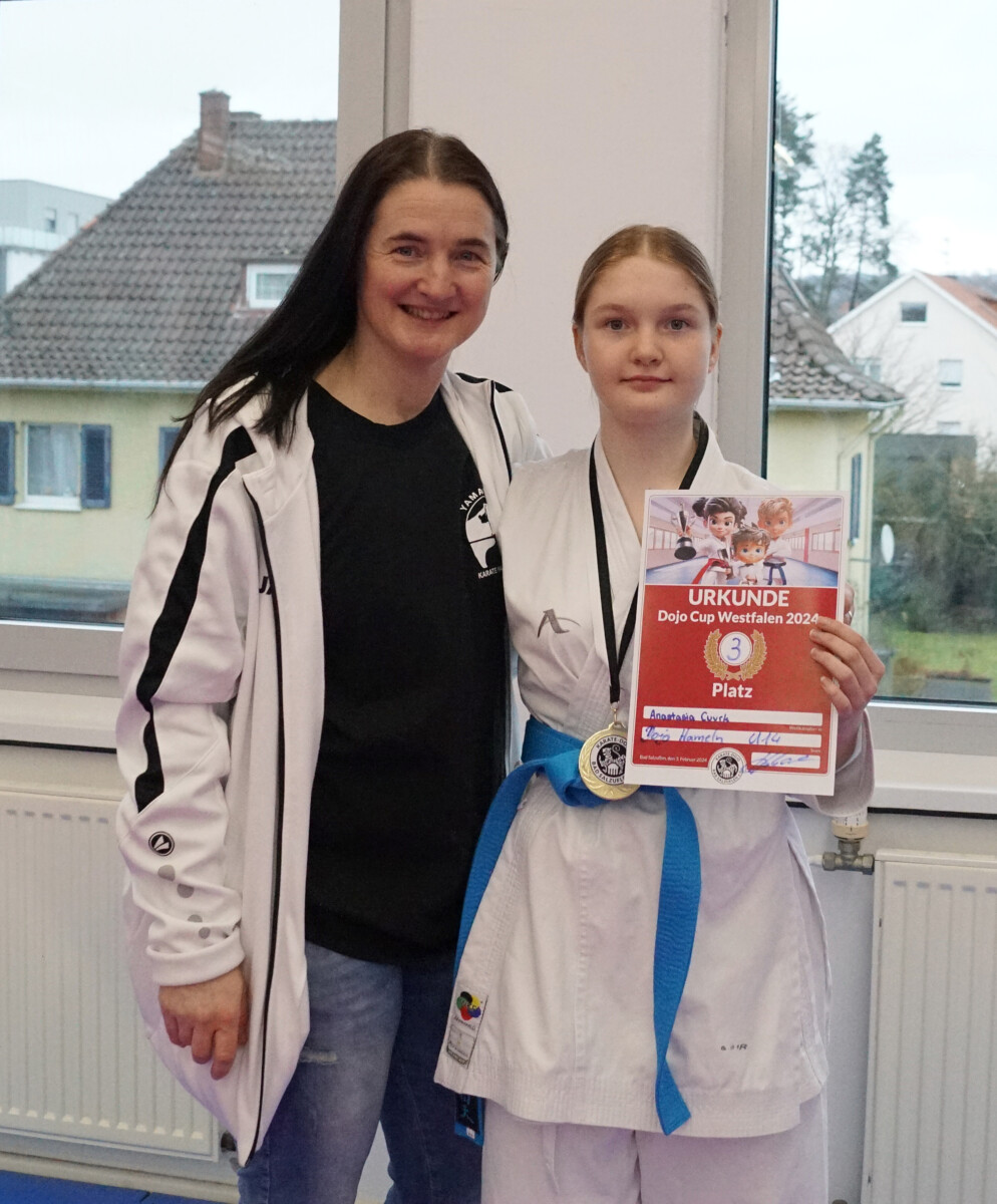 Karate-Athletin mit Trainerin und Urkunde.