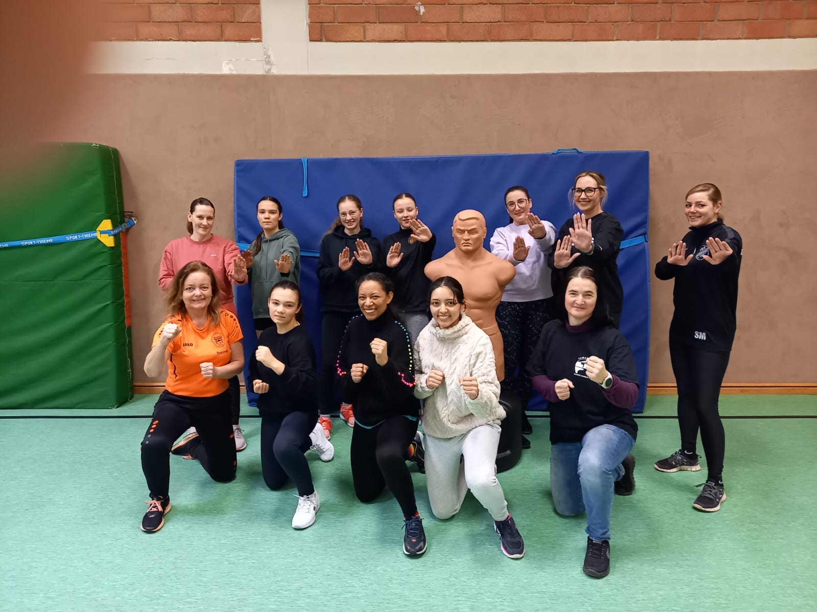Sportgruppe posiert in Selbstverteidigungshaltung.