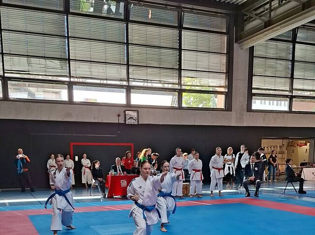 Karateka mit blauen Gürteln bei Kata auf Wettkampfmatte