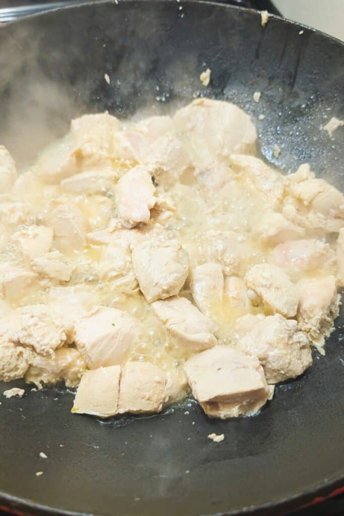 almost completely cooked chicken in wok