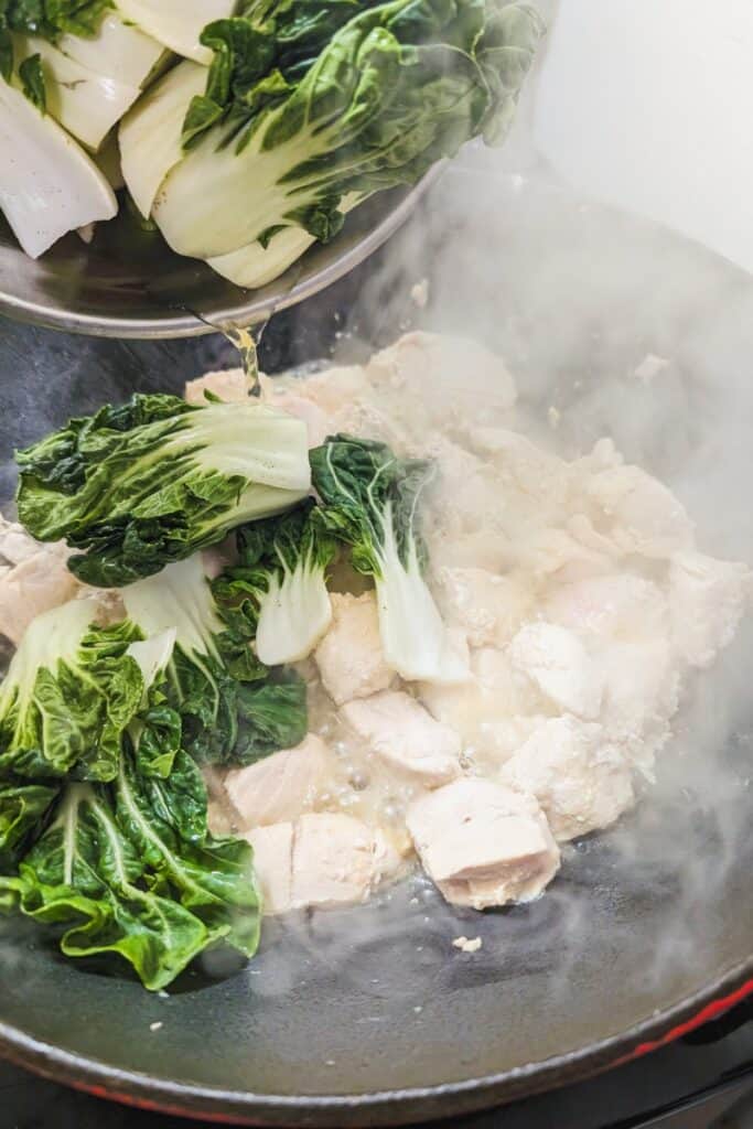 adding bok choi to wok