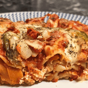 A slice of lasagna on a plate.