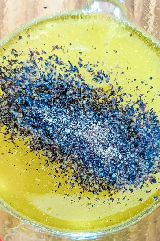 adding black pepper to salad dressing