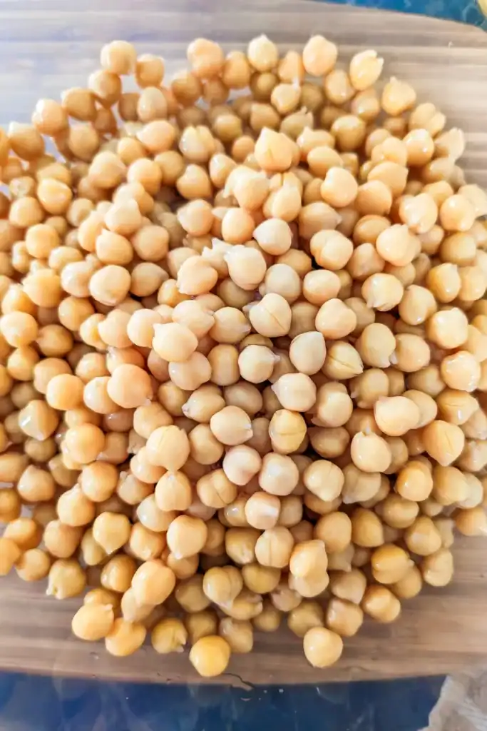 adding chickpeas to salad bowl