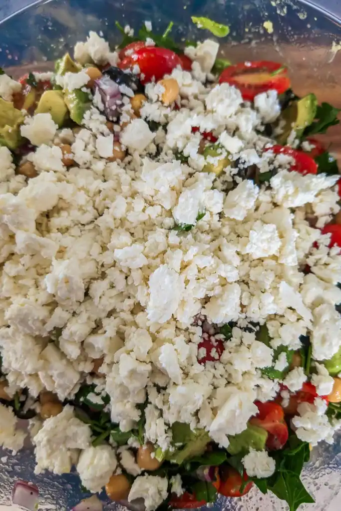 adding crumbled feta cheese to salad