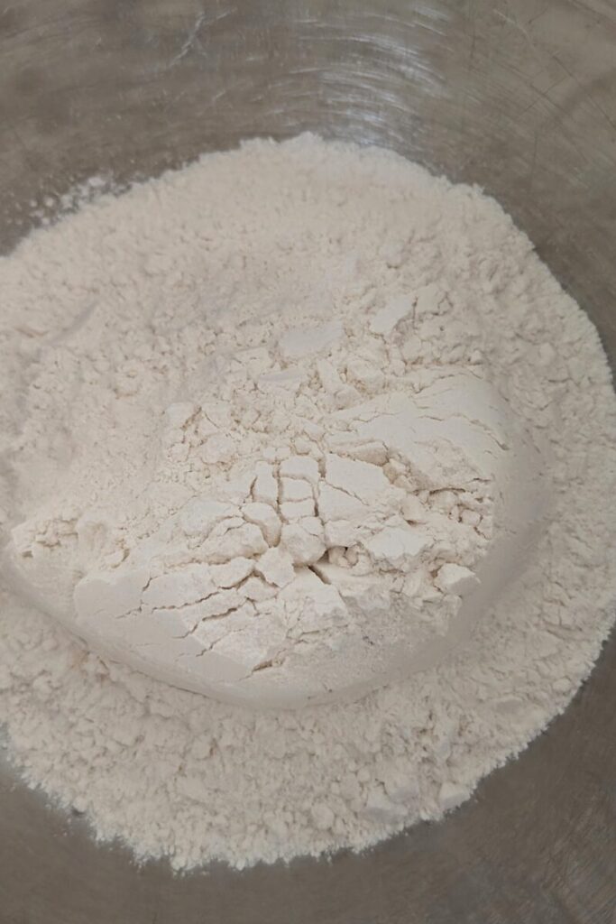adding flour to bowl