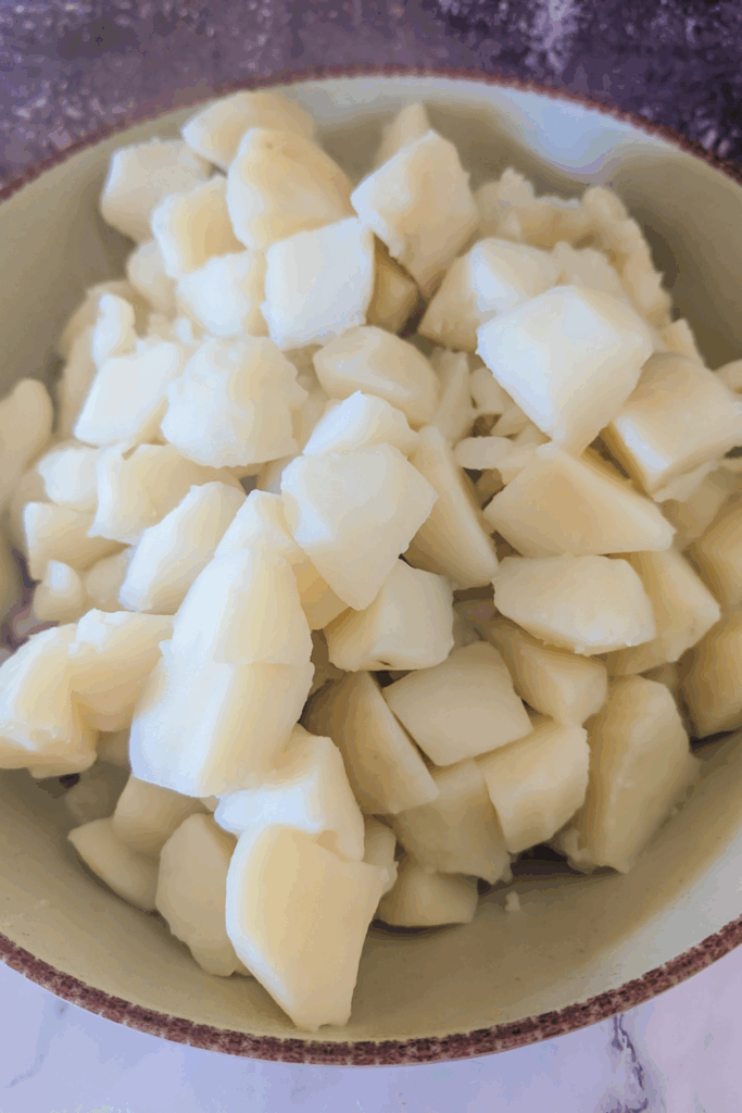 adding the cooked potato chunks to salad