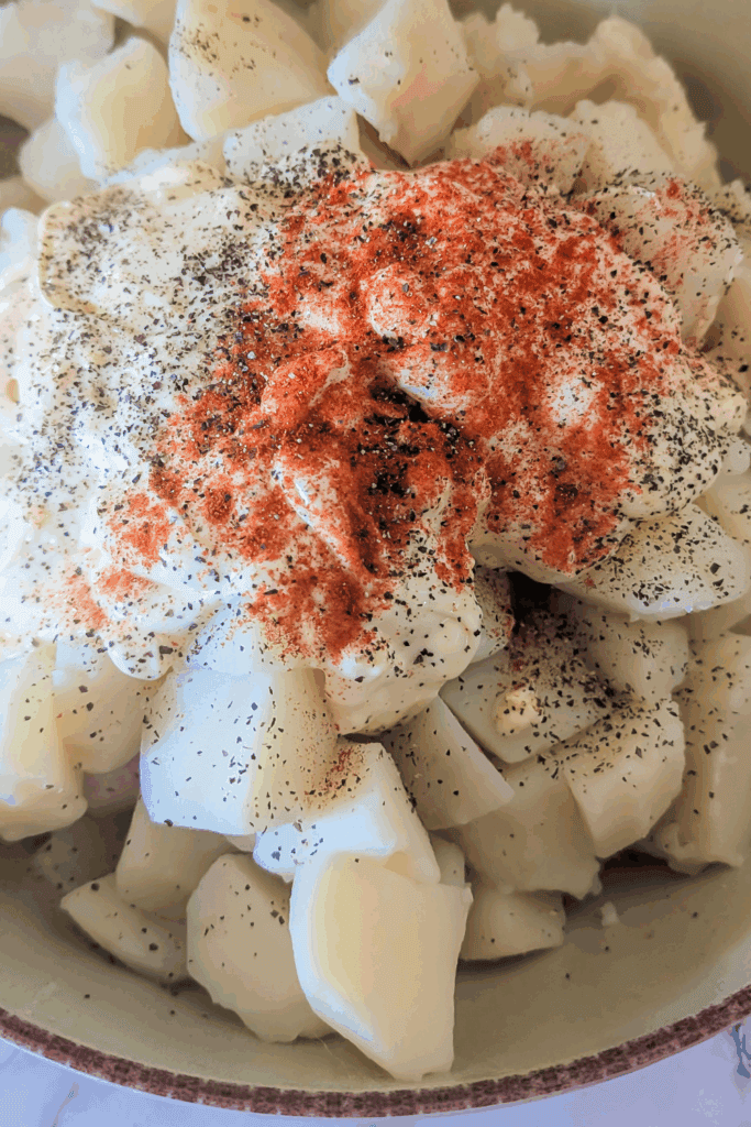 adding the paprika and pepper to salad
