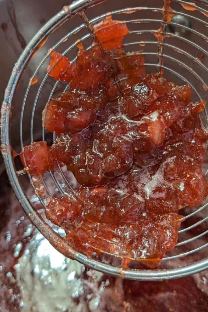 skimming fruit chunks from jam
