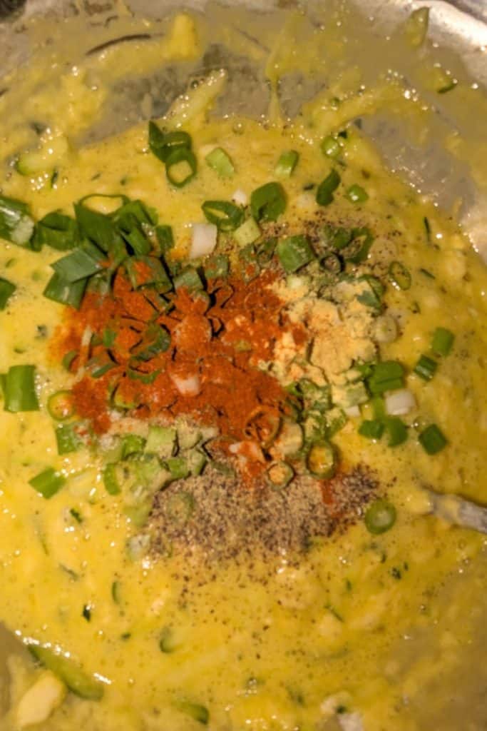 add spices to zucchini egg cheesy casserole batter