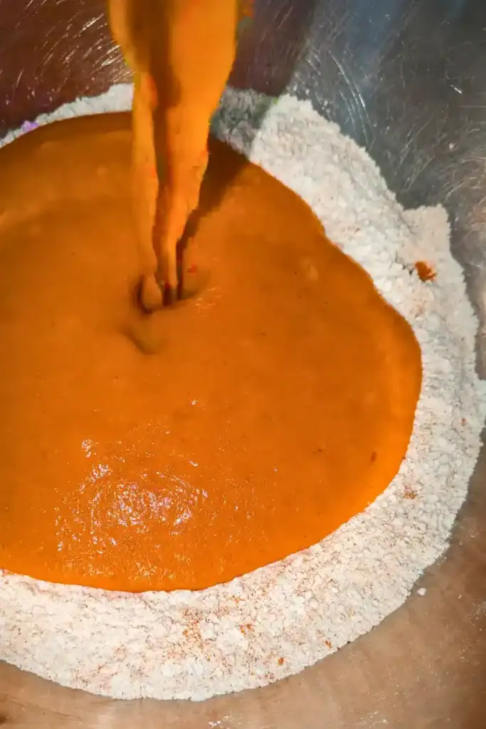 adding the wet pumpkin cake ingredients to the dry