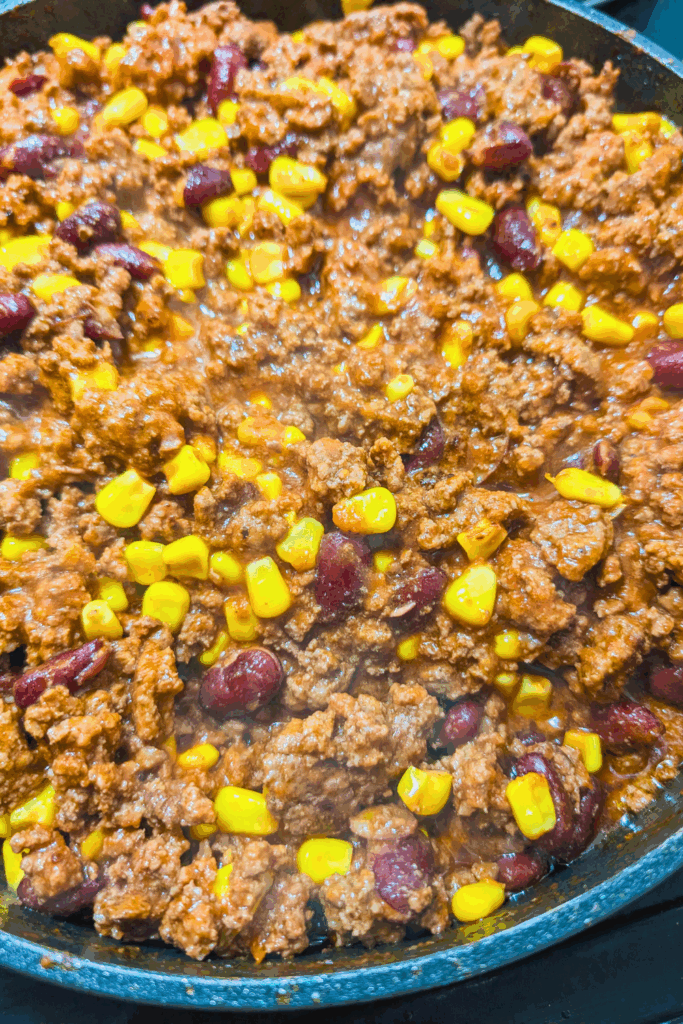 Ground beef and corn chili in a skillet, savory comfort food recipe, easy homemade chili dish.
