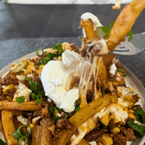 Crispy French fries with melted cheese, ground beef, sour cream, and green onions.