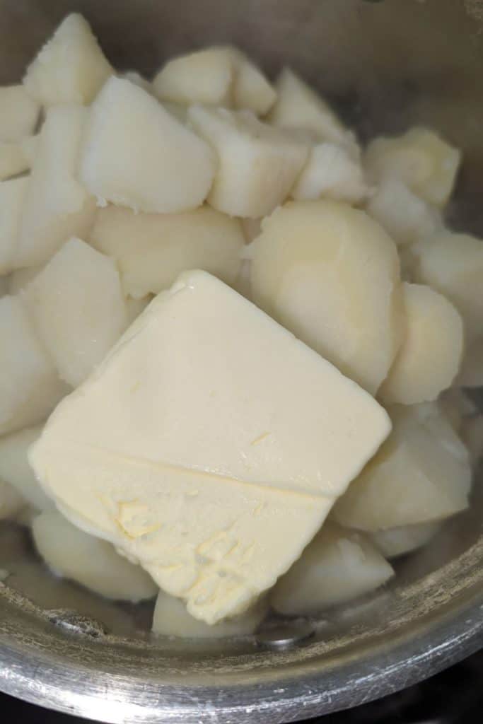 add butter to drained potato and parsnip