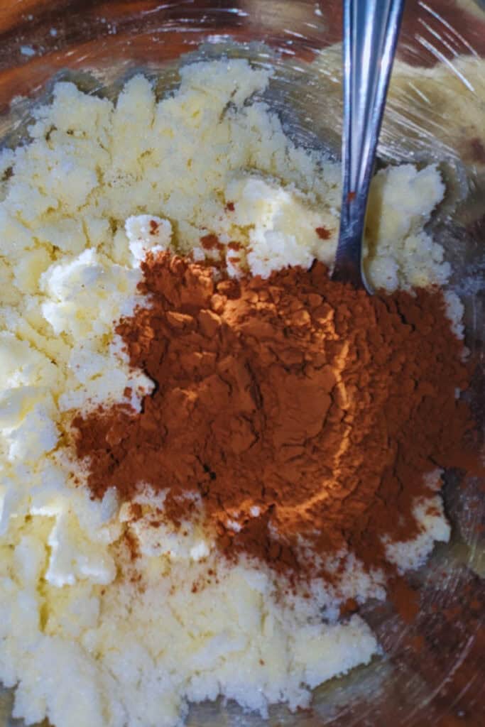 adding cocoa powder to the creamed butter