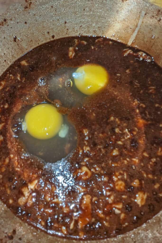 adding eggs to butter cocoa mixture