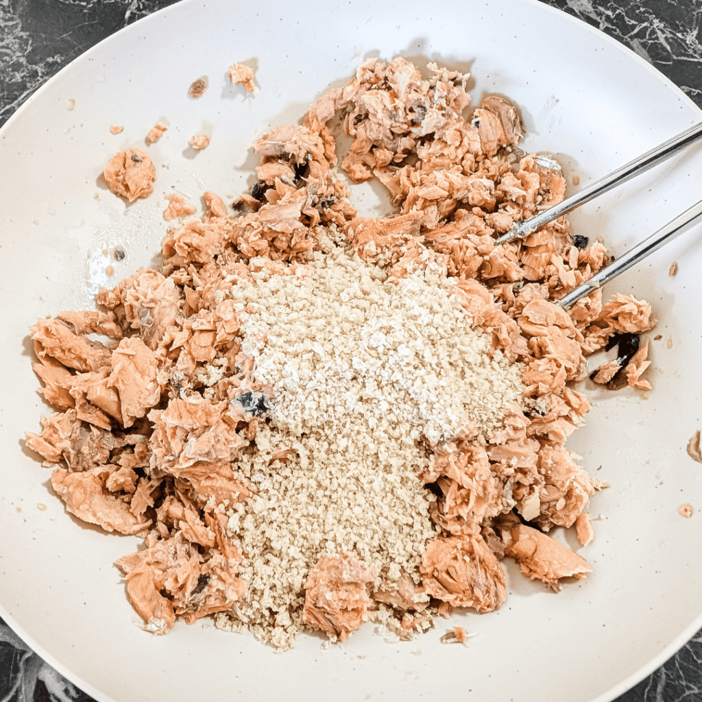 Tuna mixture with breadcrumbs in a white bowl, ready for cooking or baking.