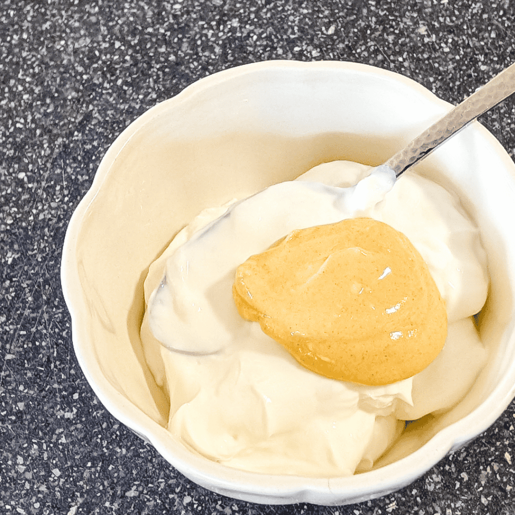 Mayonnaise with mustard in a bowl, perfect for sandwiches and salads.