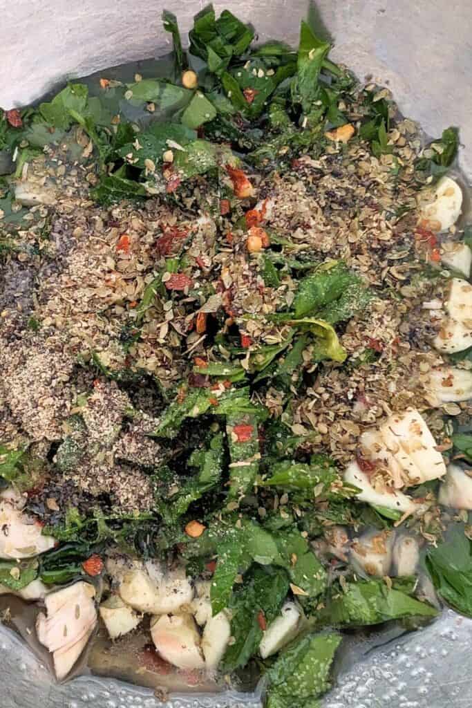 adding dry herbs to chimichurri