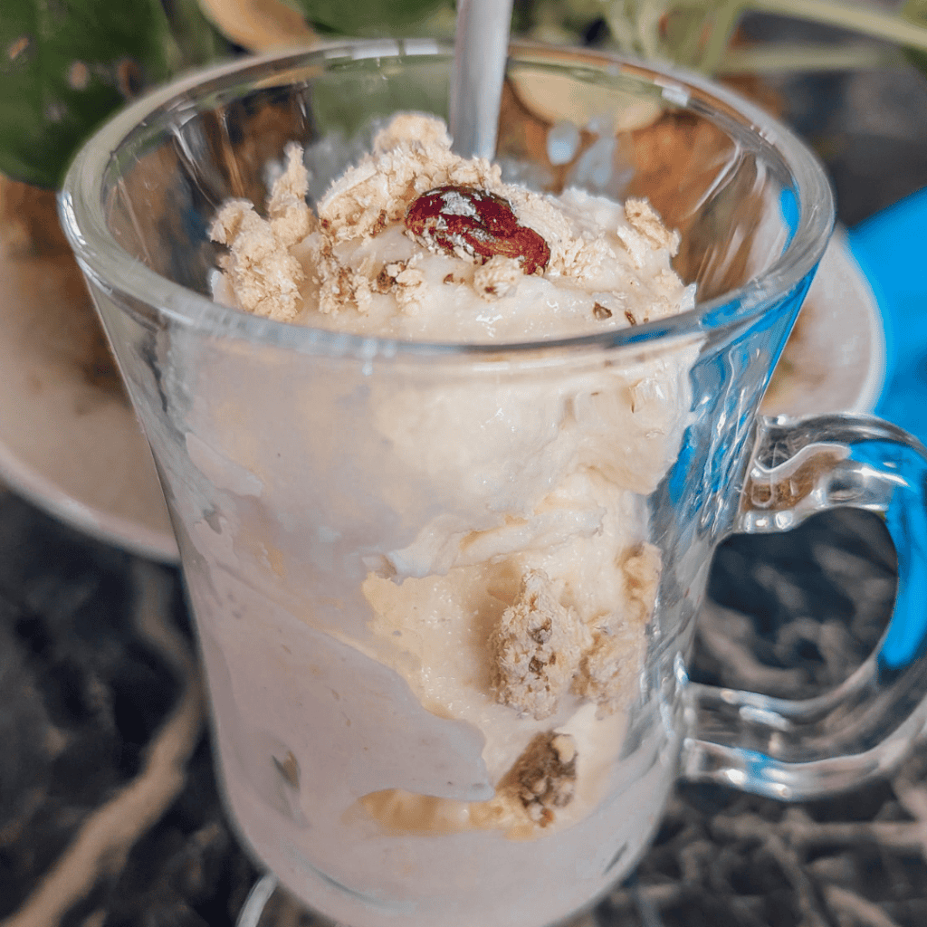 Ice cream dessert with toppings in a glass mug, perfect for summer treats.