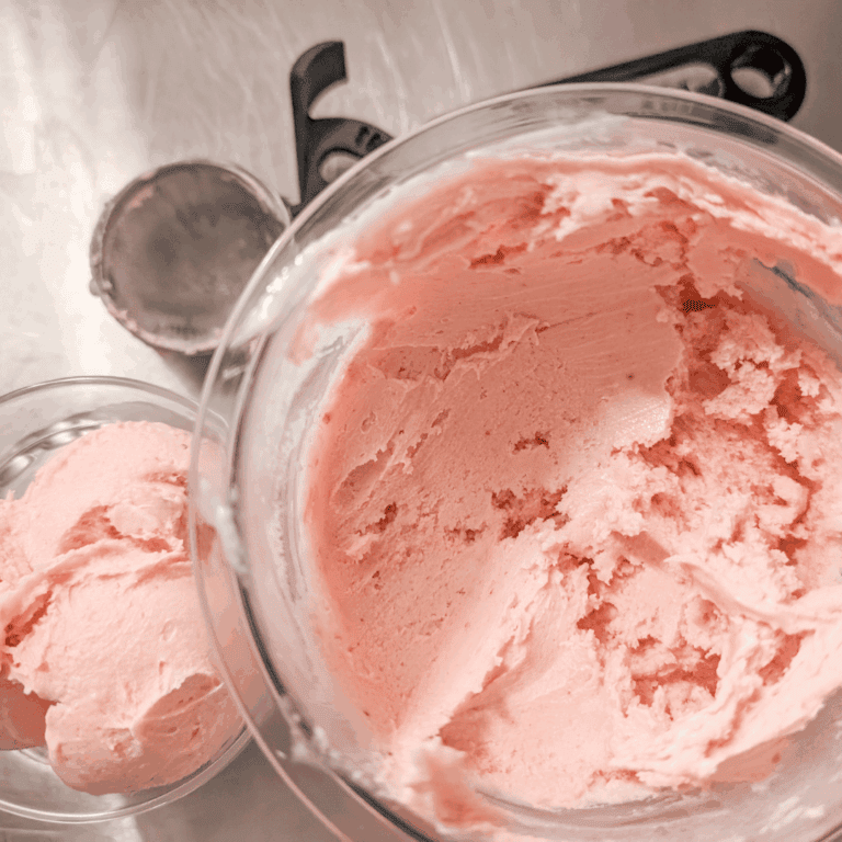 Delicious homemade strawberry ice cream in a glass bowl, perfect for summer desserts and sweet treat.