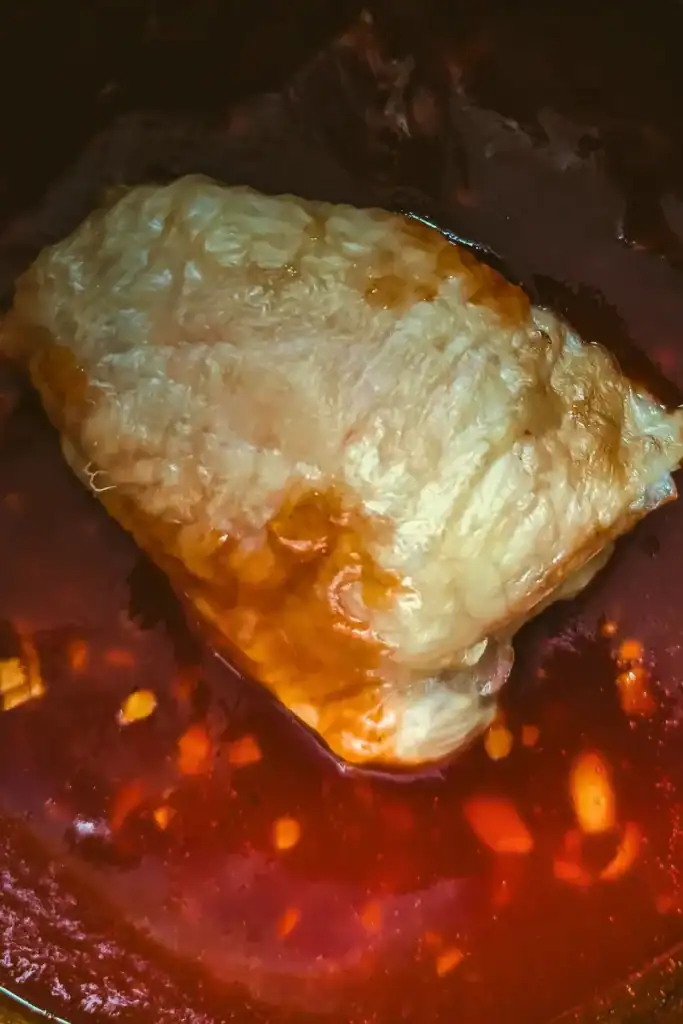 adding partially cooked chicken thighs to bbq sauce