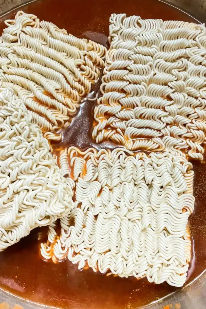 adding ramen to shrimp broth