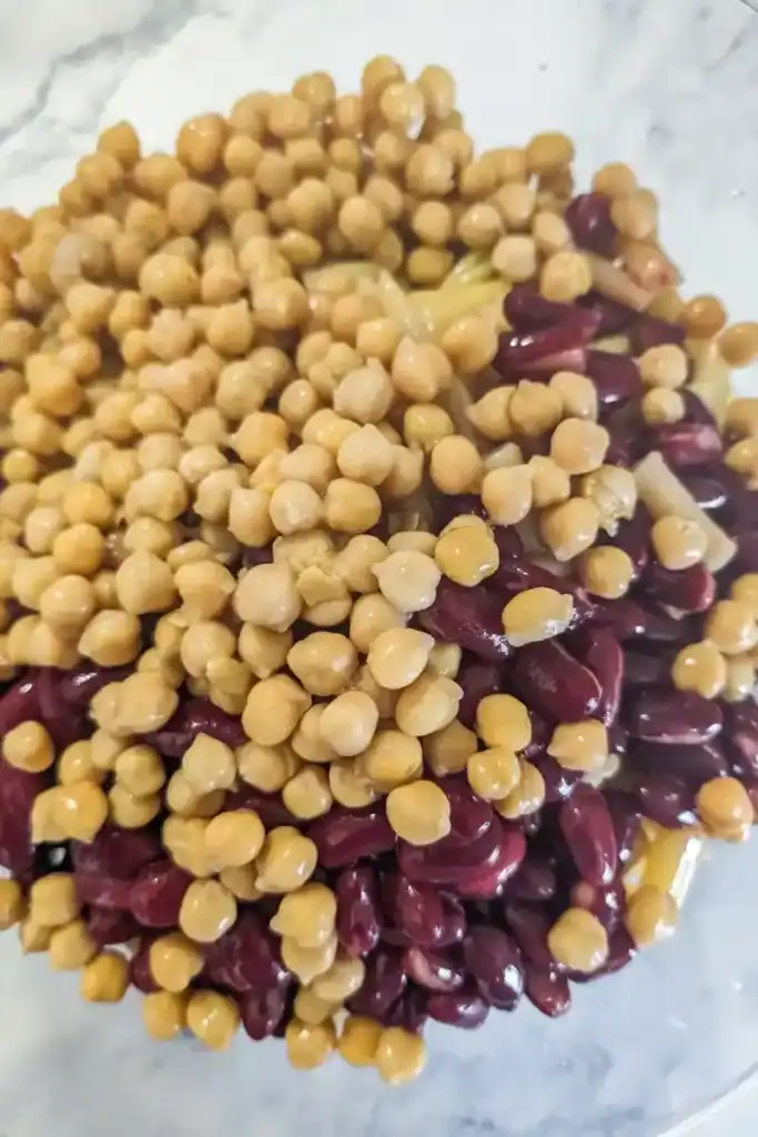 adding chickpeas to bean salad
