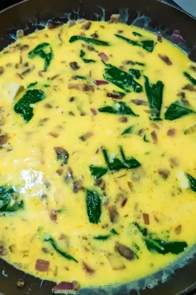 adding the egg mixture to sauteed vegetables