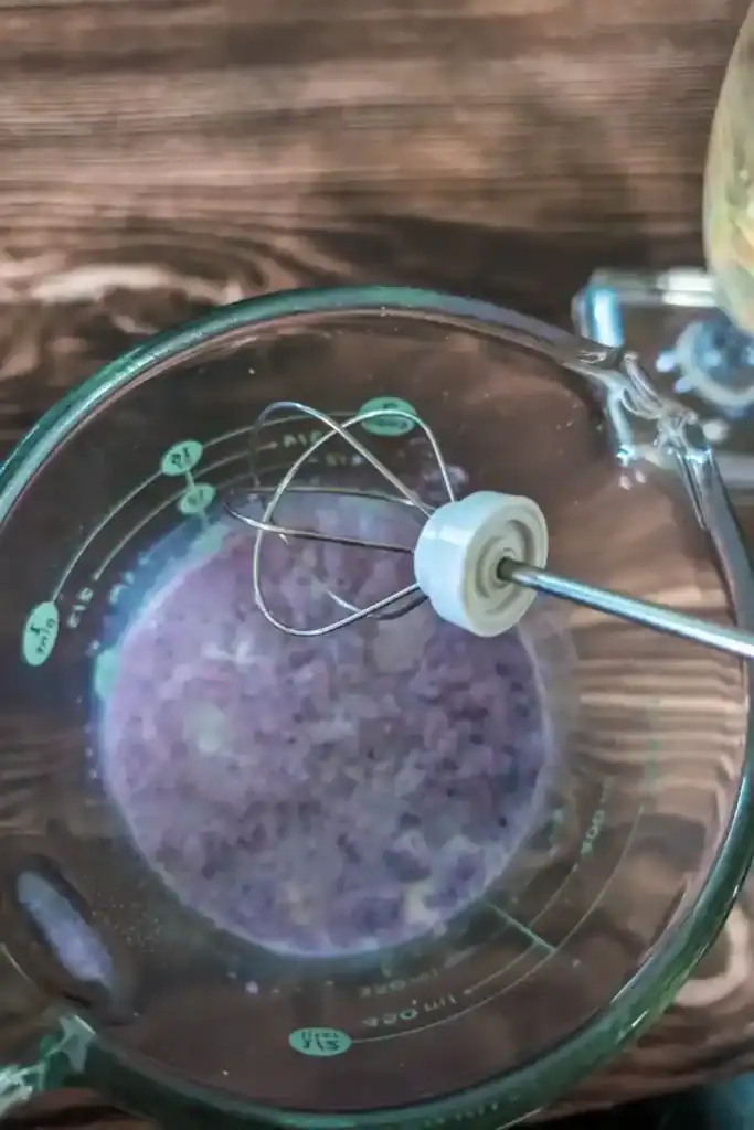 blending the taro powder with milk in measuring cup