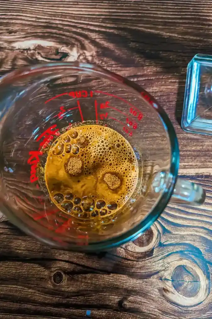 blending espresso powder sugar water in measuring cup