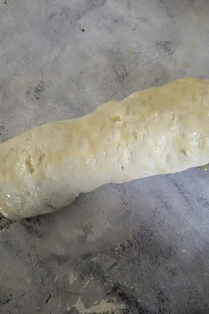 butter brushed on the outside of the biscuit roll on a light marbled background