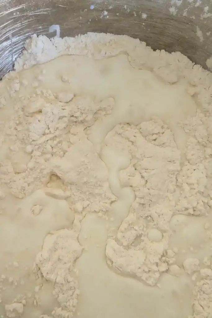 adding the buttermilk to the biscuit dough