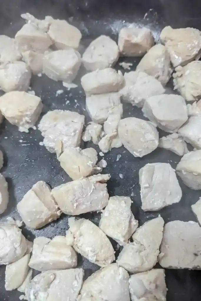 cooked chicken breast cubes in frying pan