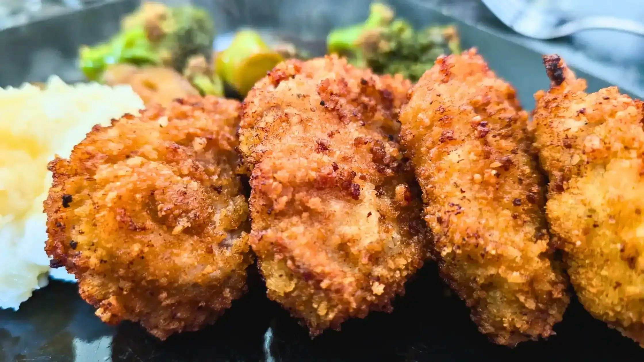 the featured image for the blog post of pork tenderloin medallions stacked in a row on a plate with mashed potato and broccoli