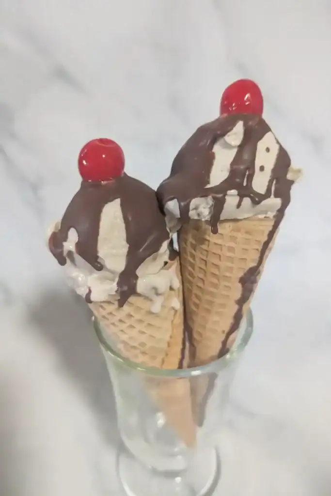 two sugar cones with banana ice cream in a irish mug