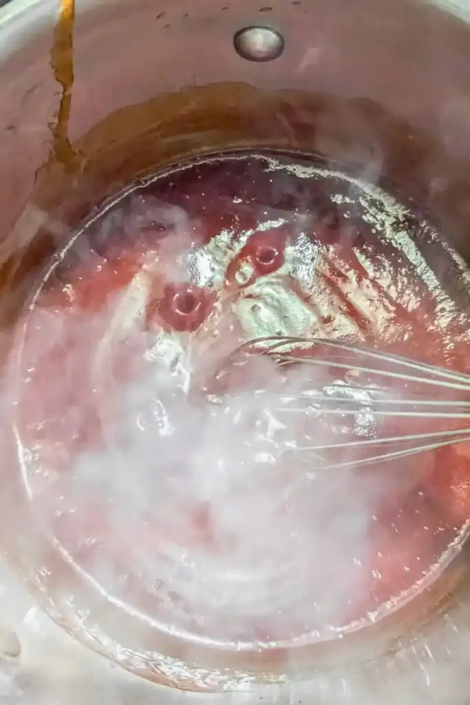 stirring the bbq sauce while heating and steaming in saucepan