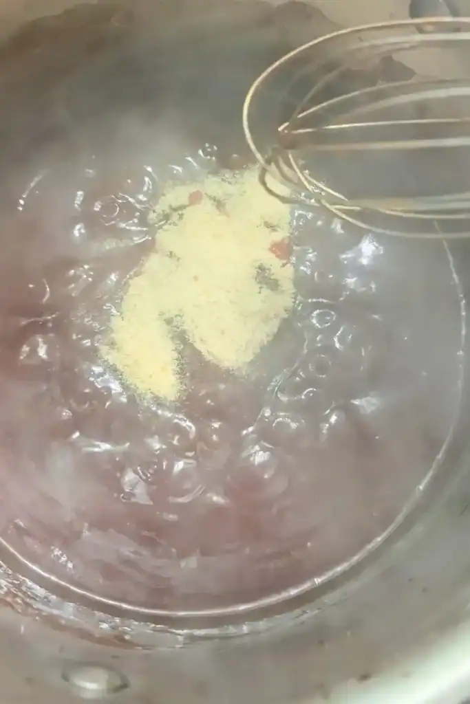 adding garlic powder and liquid smoke to the cooking bbq sauce