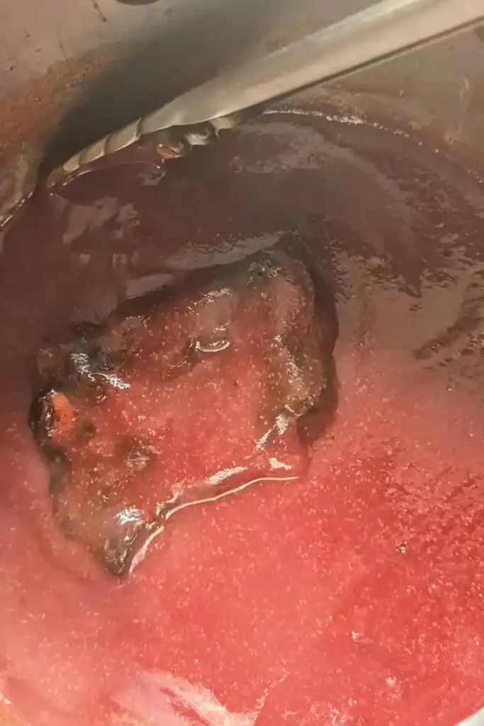 adding cooked rib section to the bbq sauce to coat