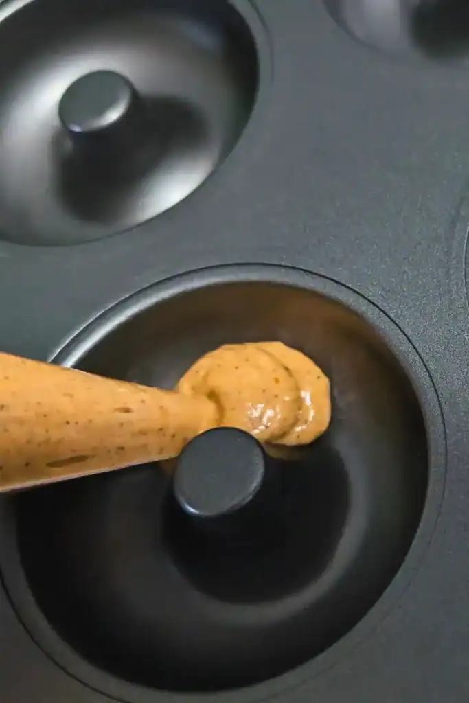 using piping bag in donut pan