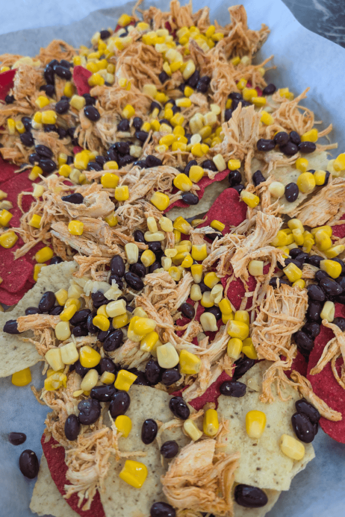 Delicious buffalo chicken nachos topped with corn, black beans, and melted cheese, perfect for a fla.