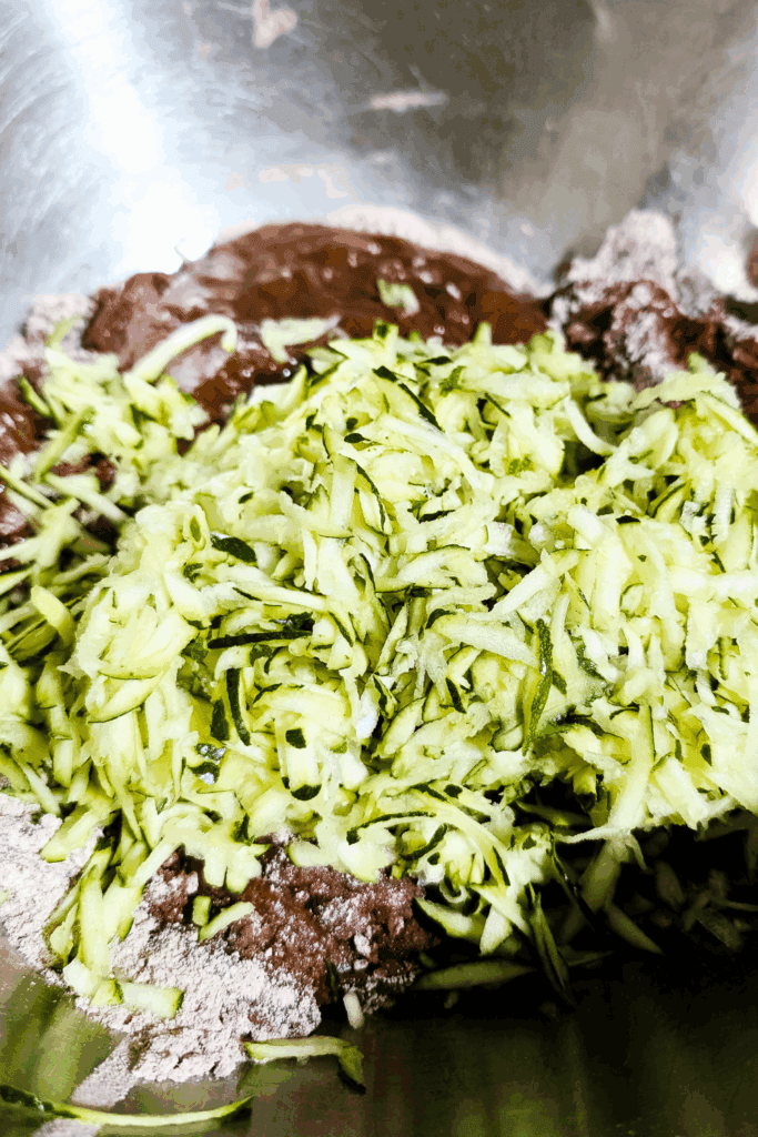 adding grated zucchini to cake batter